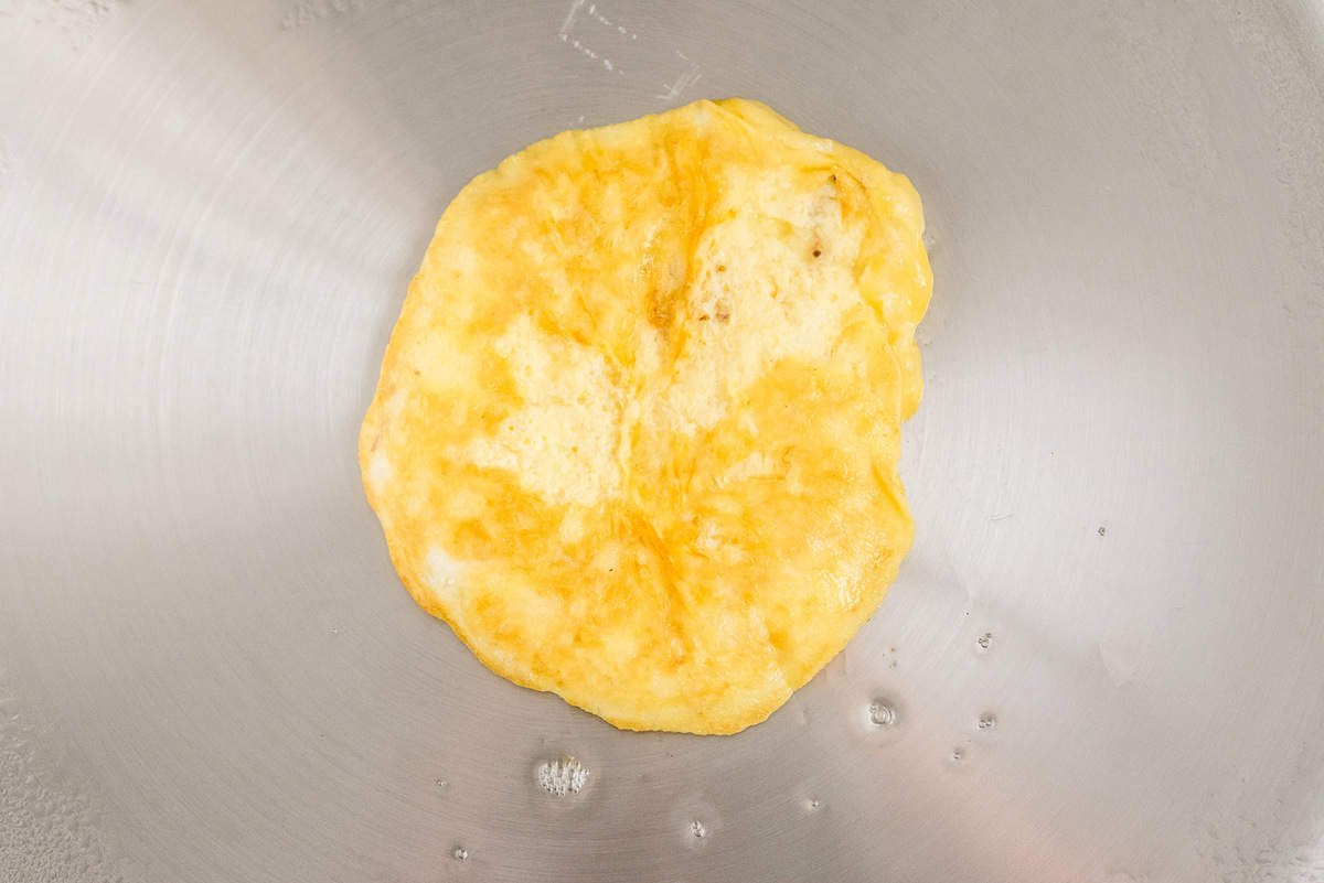 Panqueca de ovo e banana em uma frigideira de aço inoxidável.