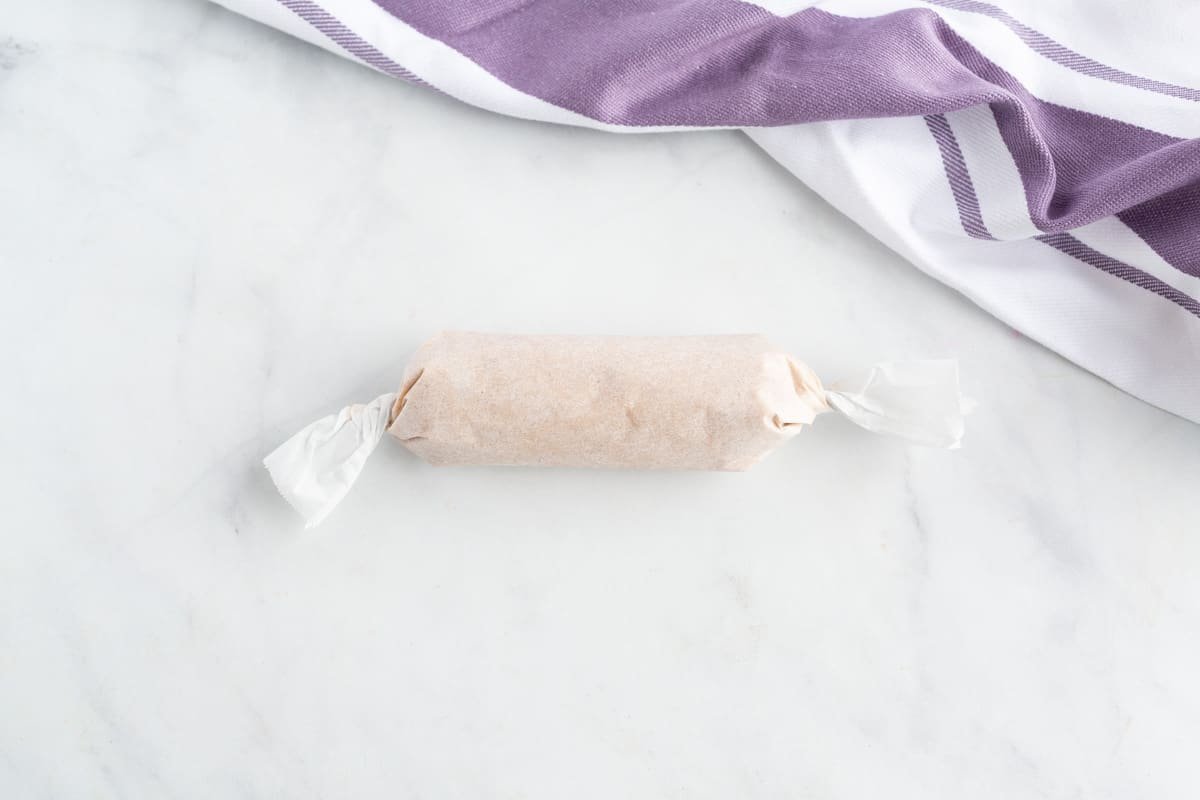 Manteiga de canela e maple enrolada em papel manteiga.