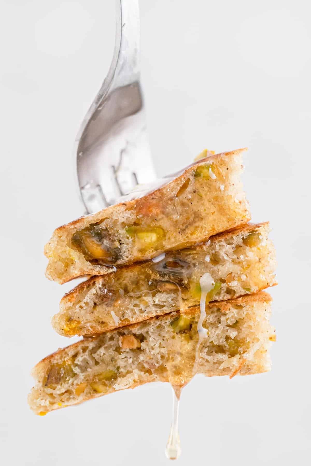 Panquecas num garfo, a pingar com mel.