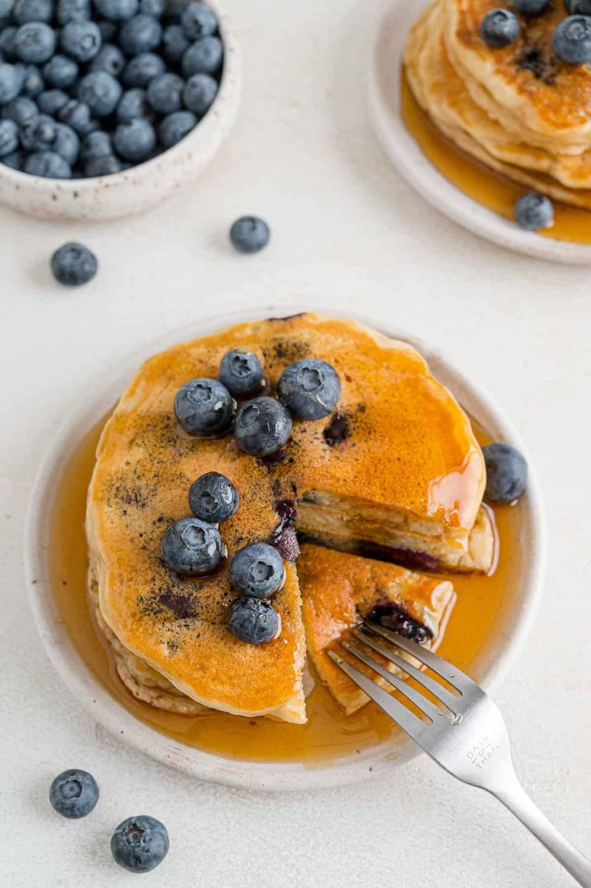 Garfo pegando uma panqueca do monte de panquecas.