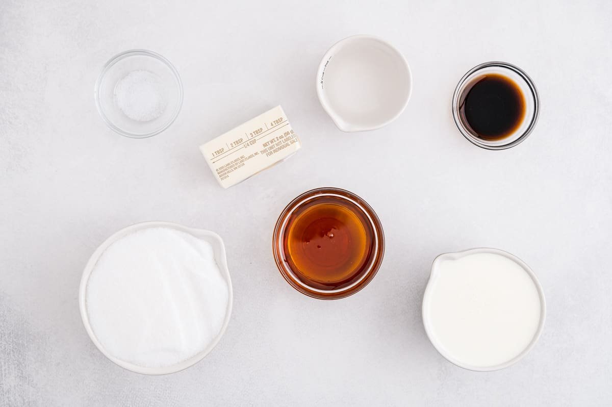 Visão aérea dos ingredientes necessários para a receita: creme, baunilha, manteiga, sal, xarope de milho, açúcar.