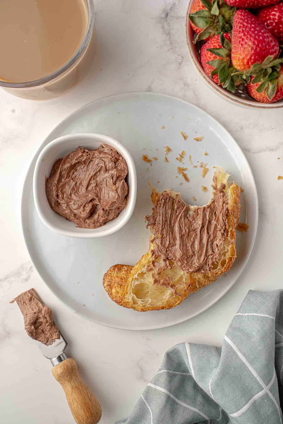 Croissant com manteiga de chocolate com um bocado retirado.