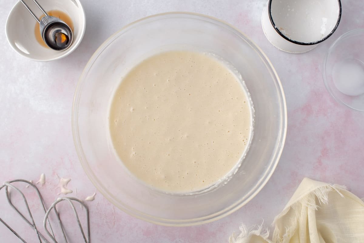 Glacê de queijo creme em uma tigela de vidro transparente.