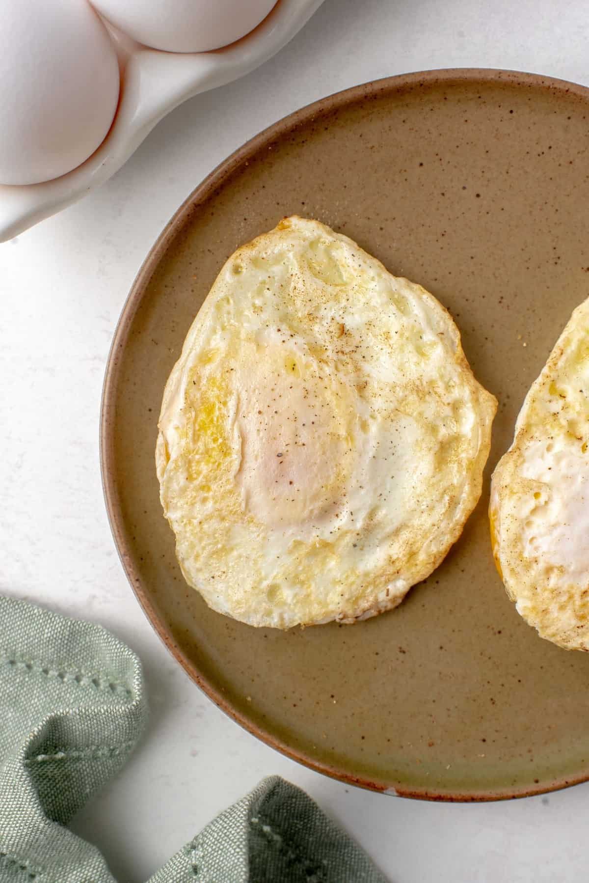 Ovo médio em um prato marrom.