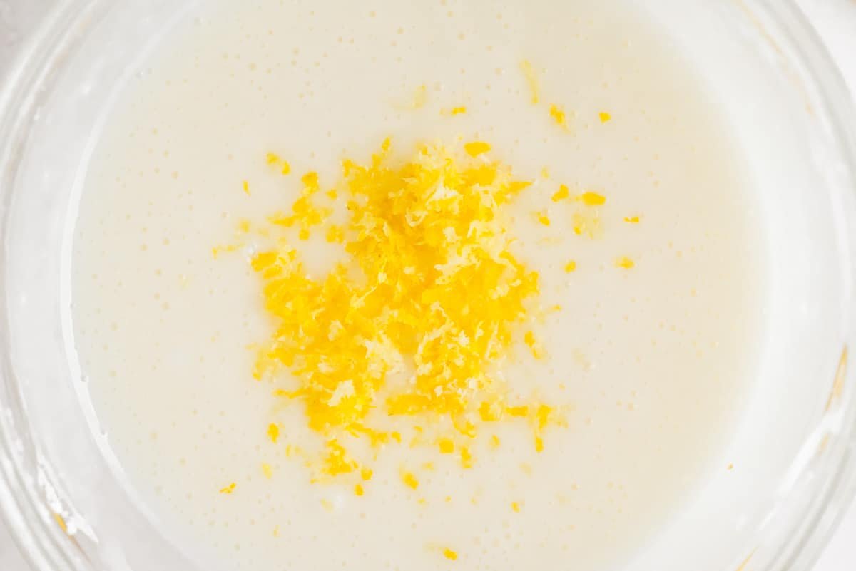 Raspas de limão por cima do glacê de limão.