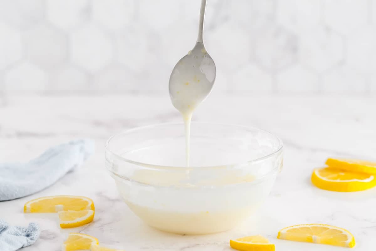 Glacê de limão em um prato de vidro, colher flutuando acima.