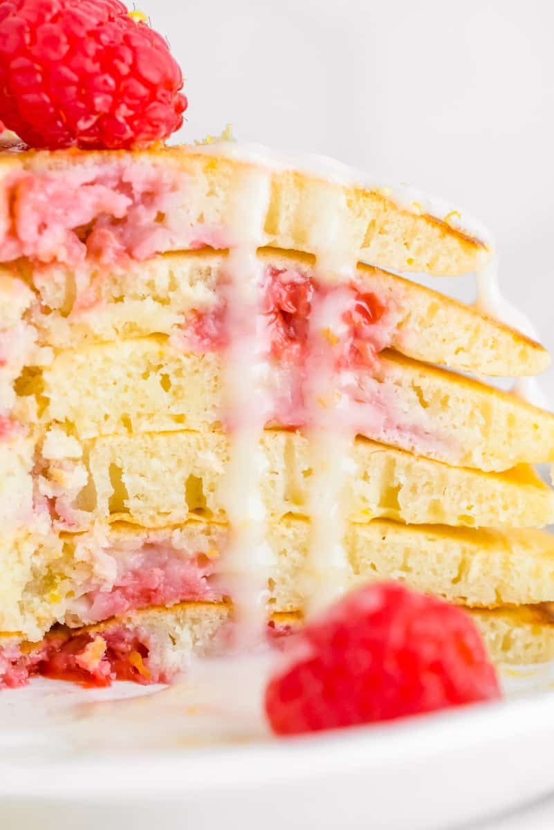 Glacê de limão escorrendo nas laterais de panquecas de framboesa e limão.