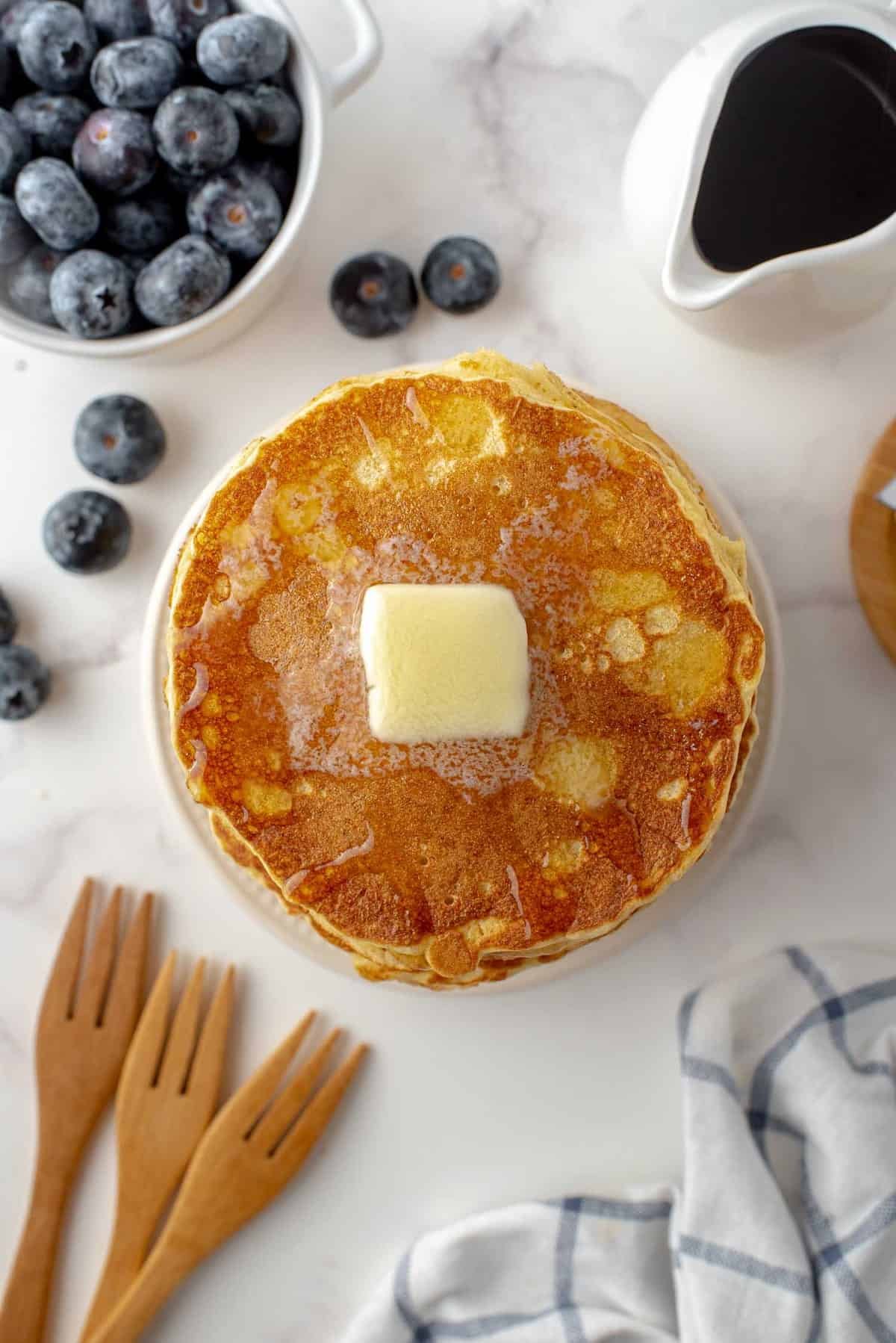 Vista superior de panquecas com um pedaço de manteiga.