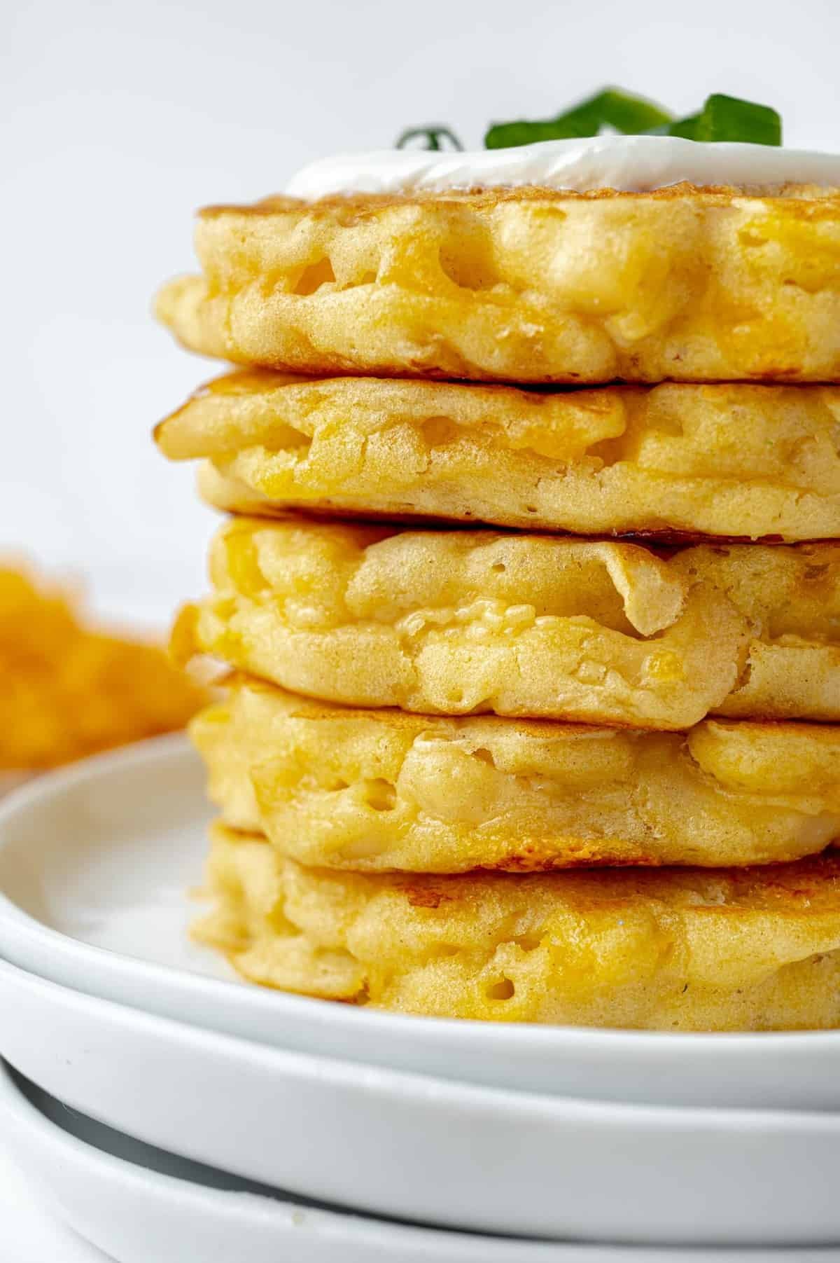 Panquecas empilhadas e cobertas com creme azedo.