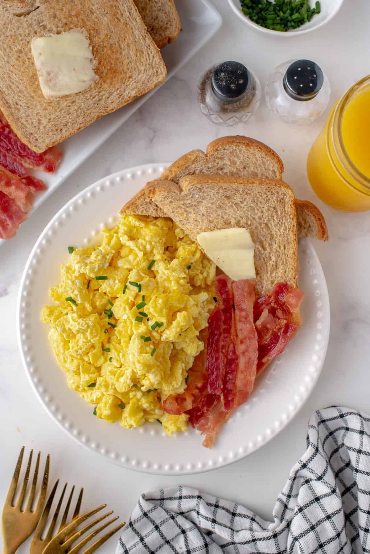 Vista aérea de um prato de pequeno-almoço com ovos, bacon e torrada.