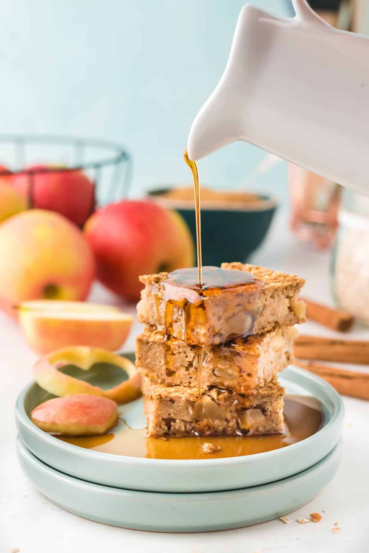 Aveia com maçã e canela com xarope sendo derramado sobre ela.