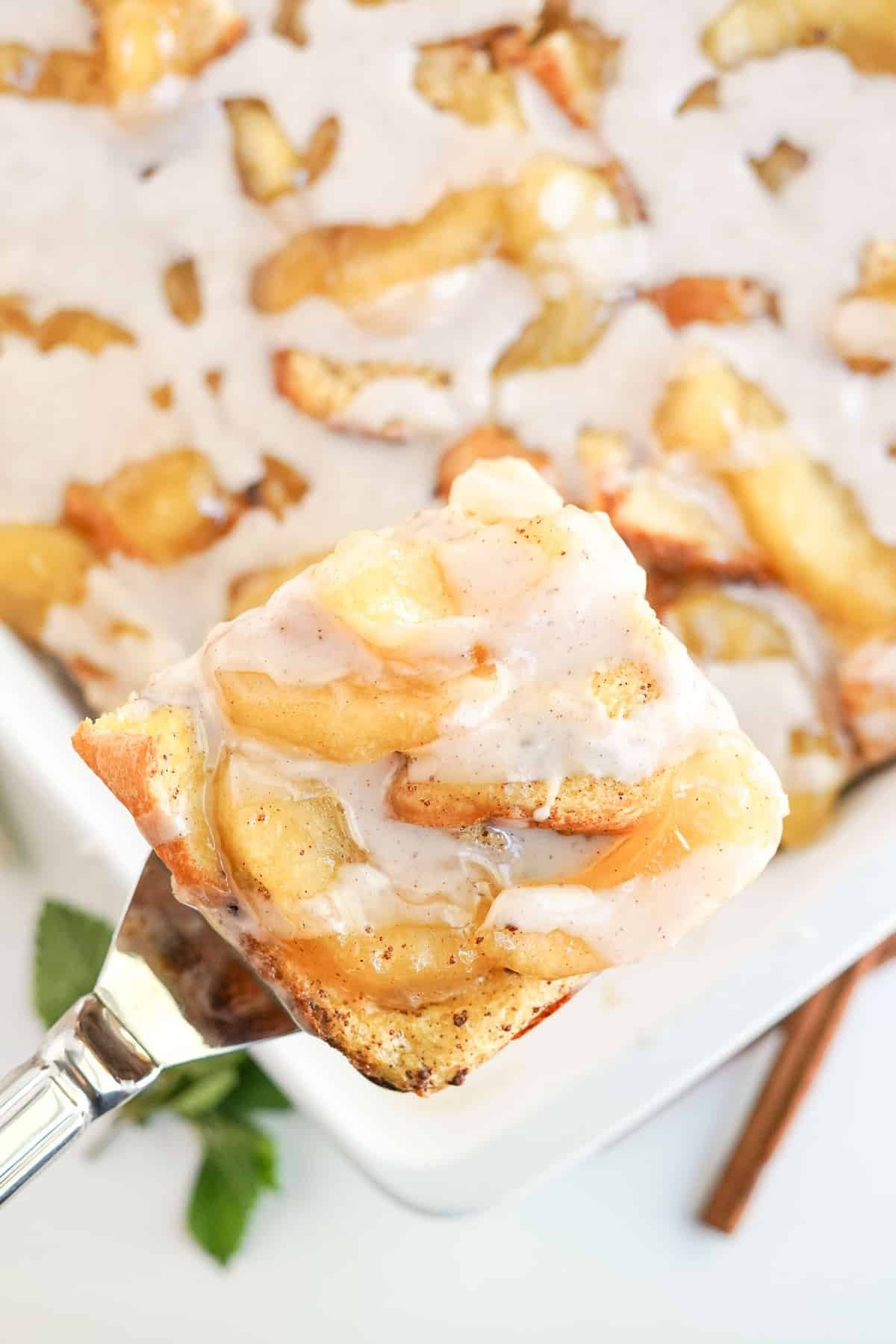 Fatia de panqueca de maçã sendo retirada da forma.