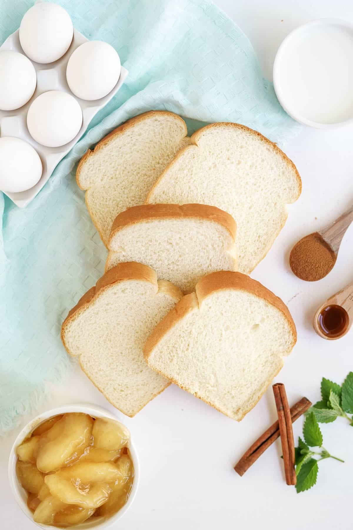 Visão aérea dos ingredientes necessários, incluindo pão fatiado.
