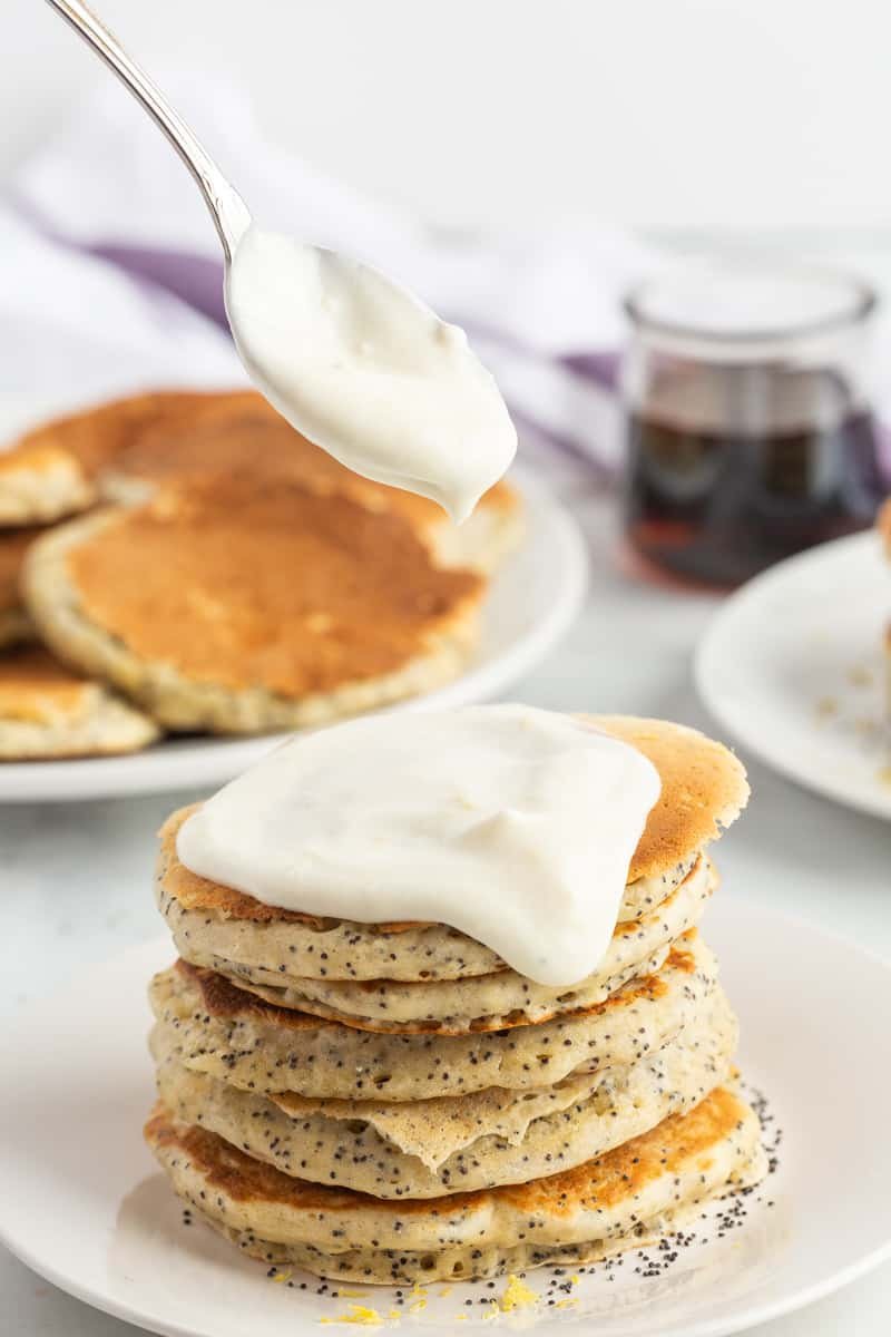 Cobertura de queijo creme com limão sendo colocada em panquecas.