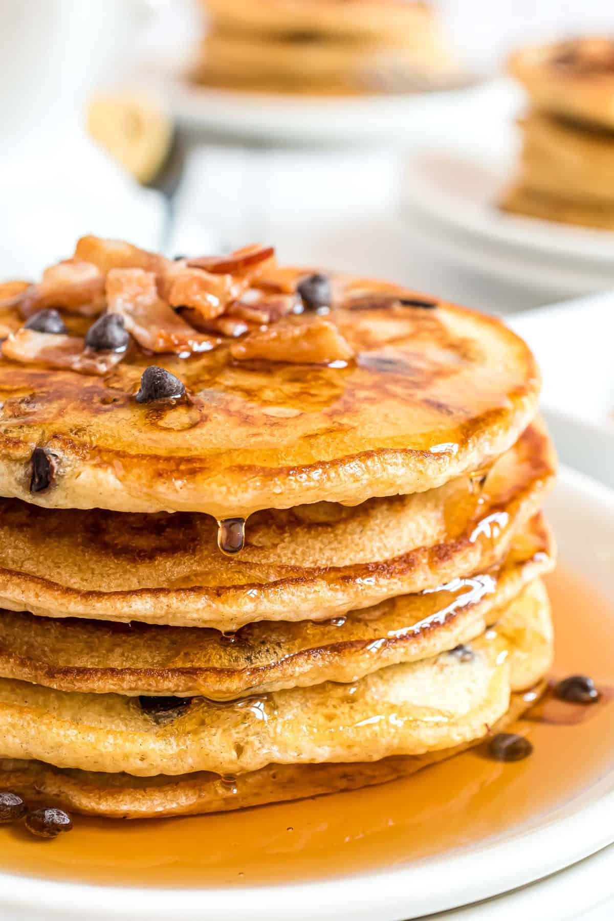 Pilha de panquecas de chocolate com bacon e xarope.