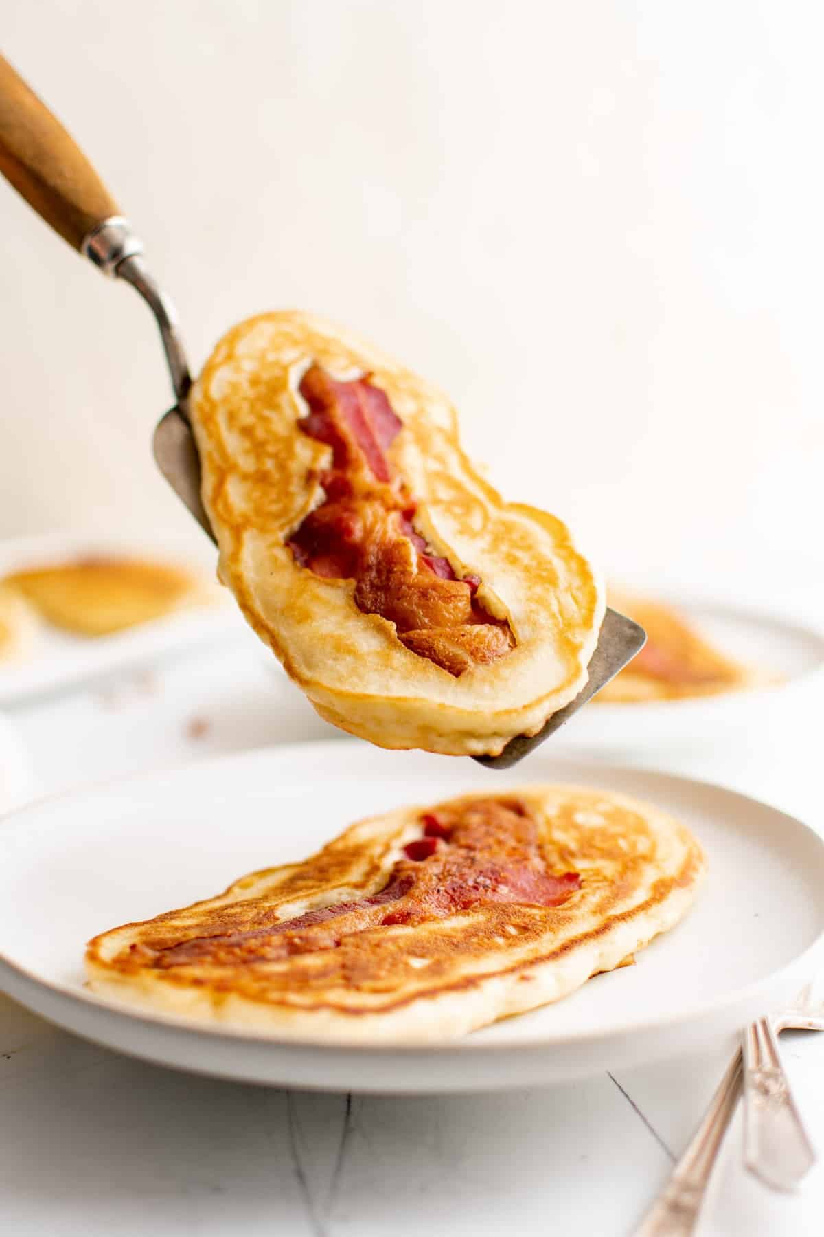 Panqueca com bacon em uma espátula.