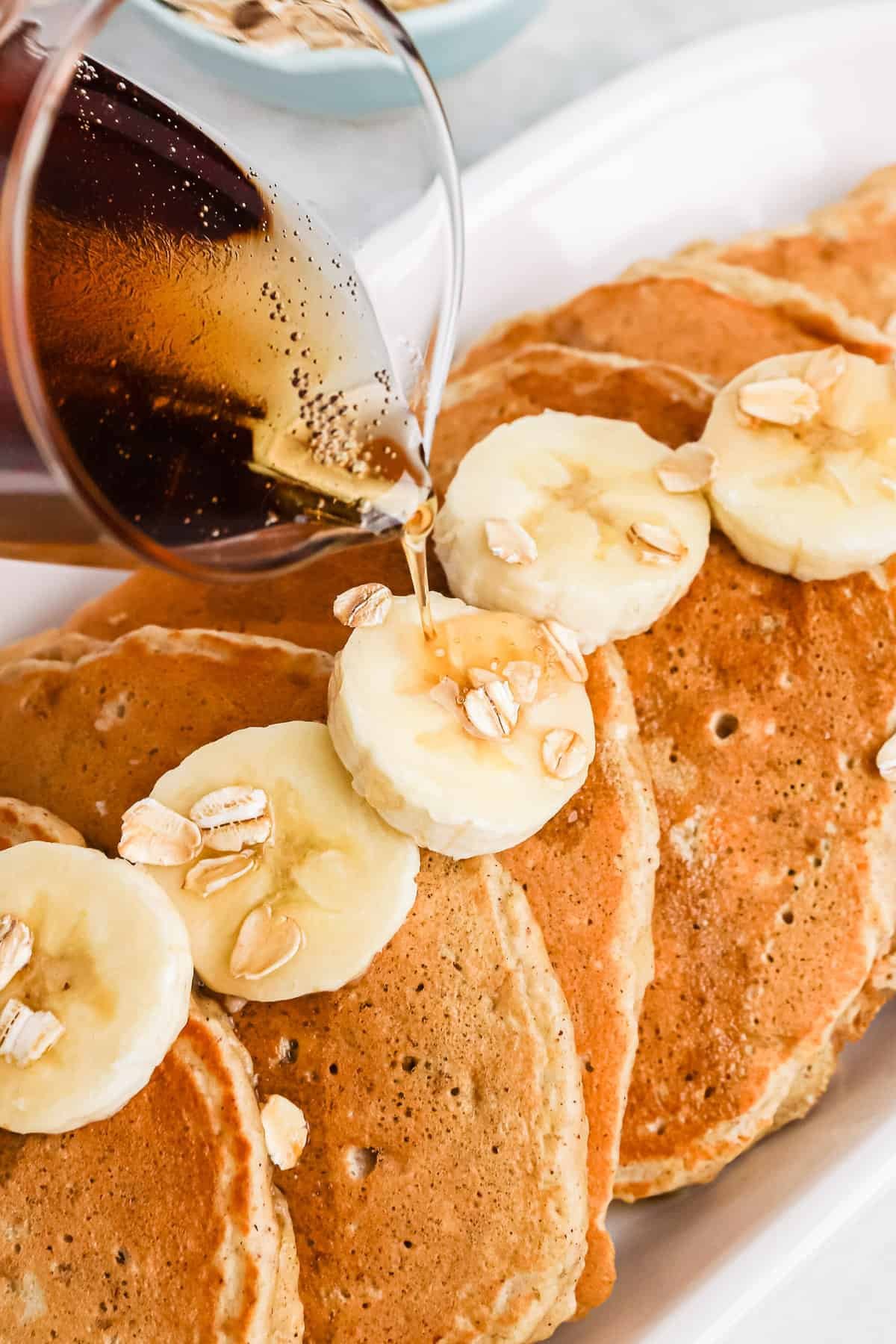 Xarope a ser vertido sobre panquecas de banana.