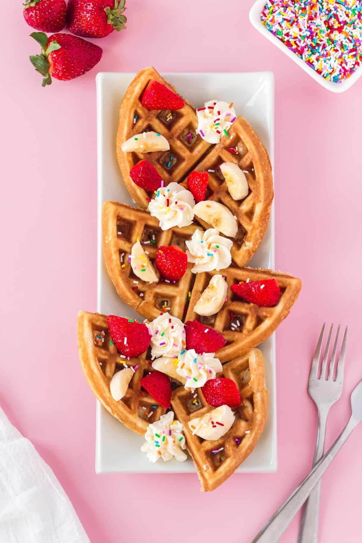 Waffles servidas em quartos em um prato retangular.