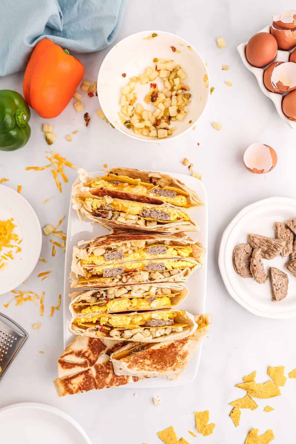 Vista superior de metades de crunchwrap em fileira em um prato retangular branco.