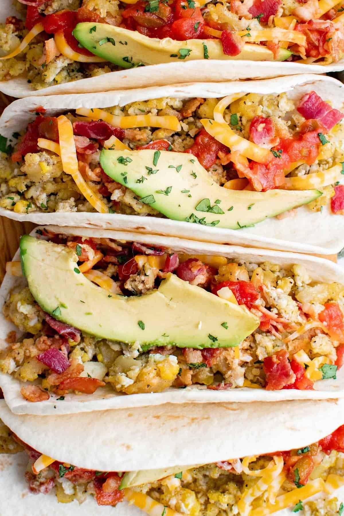 Vista de perto de tacos de café da manhã com fatias de abacate.