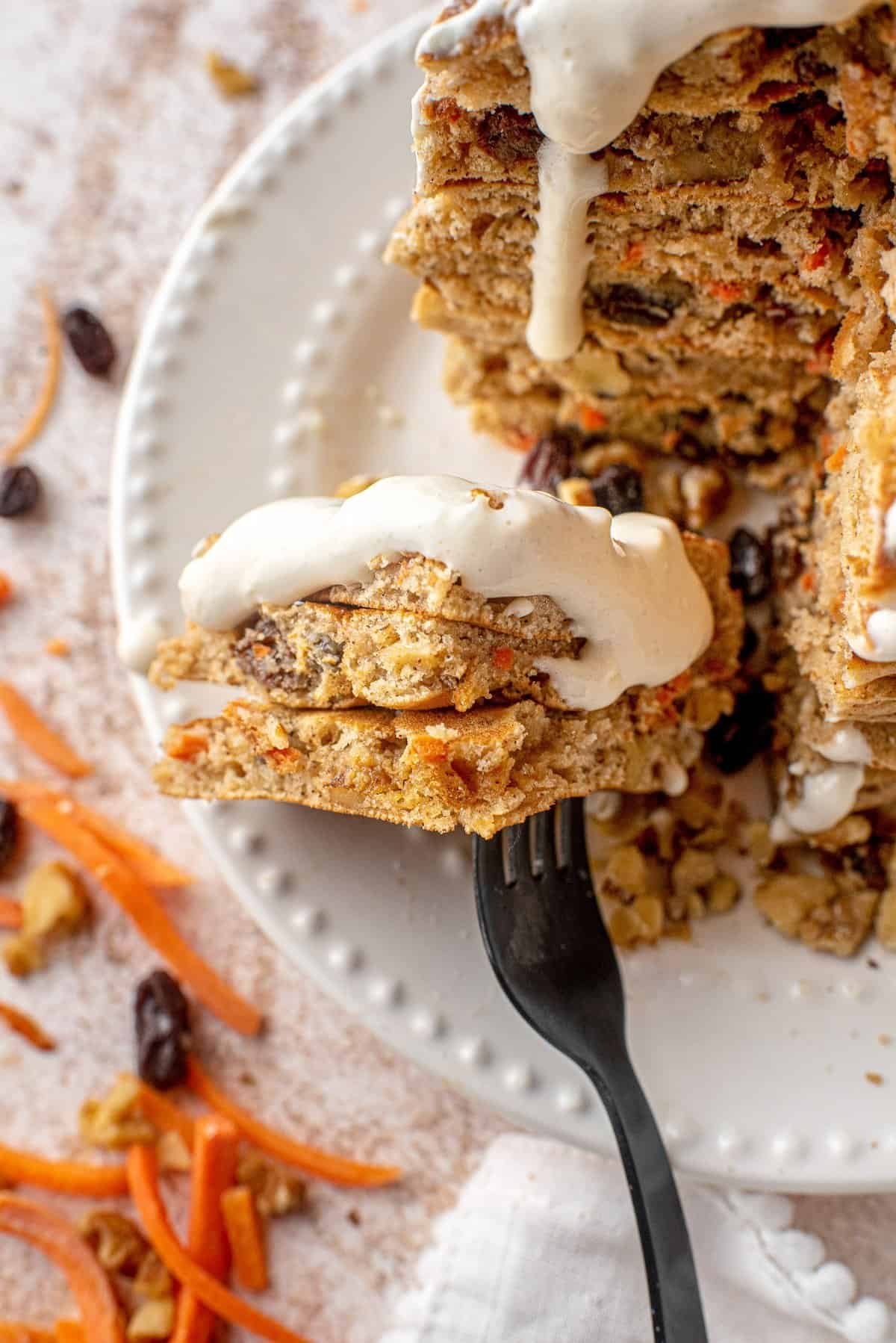 Panquecas de bolo de cenoura, cortadas para mostrar textura, com glacê branco.