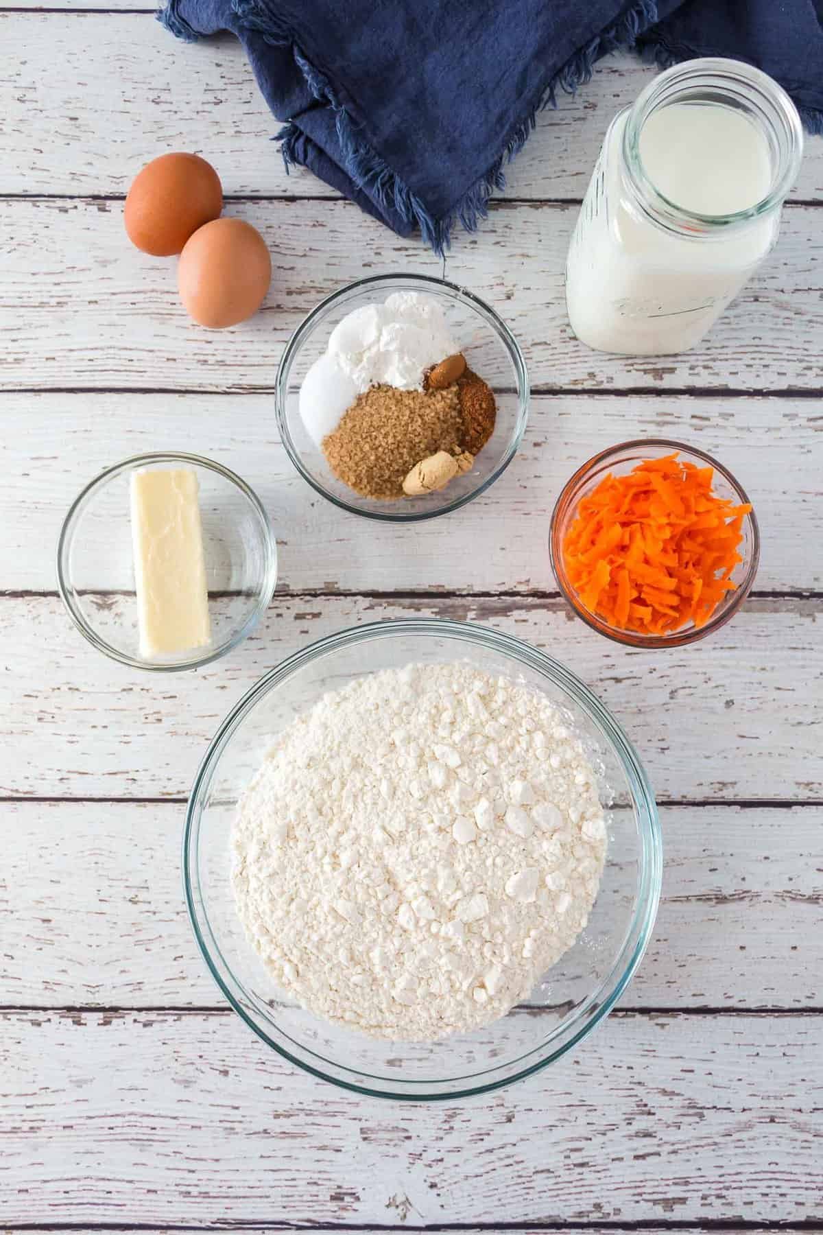 Visão aérea dos ingredientes: Farinha, cenouras, leite, ovos, especiarias. açúcar.