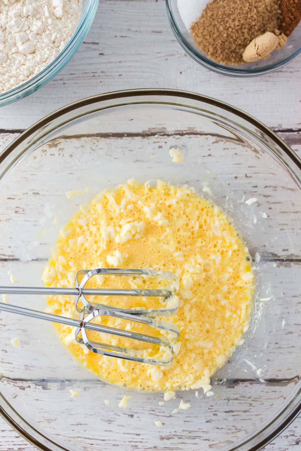 Ovos e manteiga batidos juntos em uma tigela.