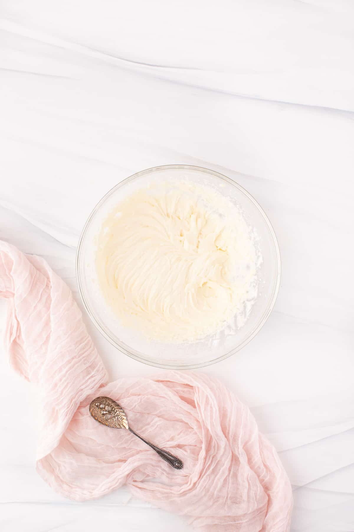 Cobertura de queijo creme em uma tigela de mistura de vidro.