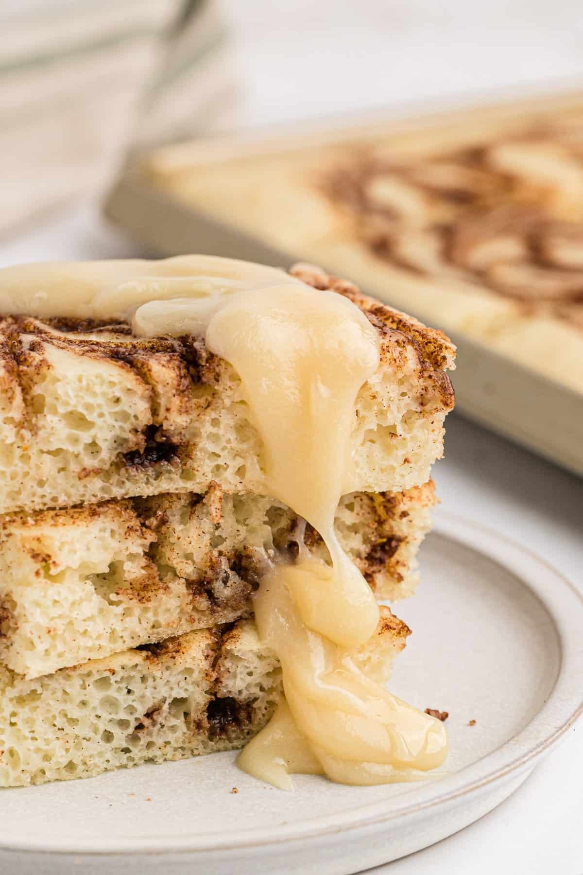 Cobertura de queijo creme escorrendo sobre pilha de panquecas.