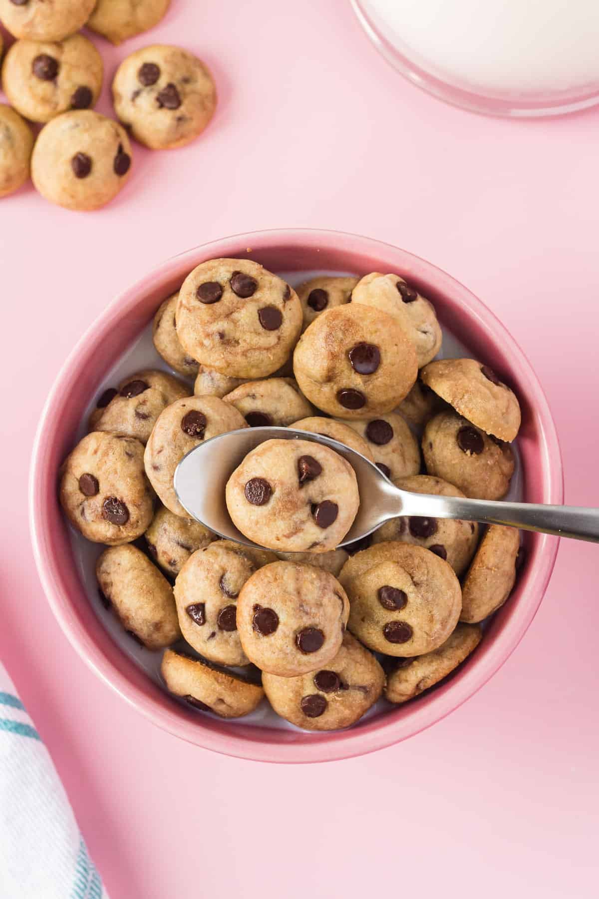 Vista aérea de uma taça de cereal de cookies caseiros contra fundo cor-de-rosa.