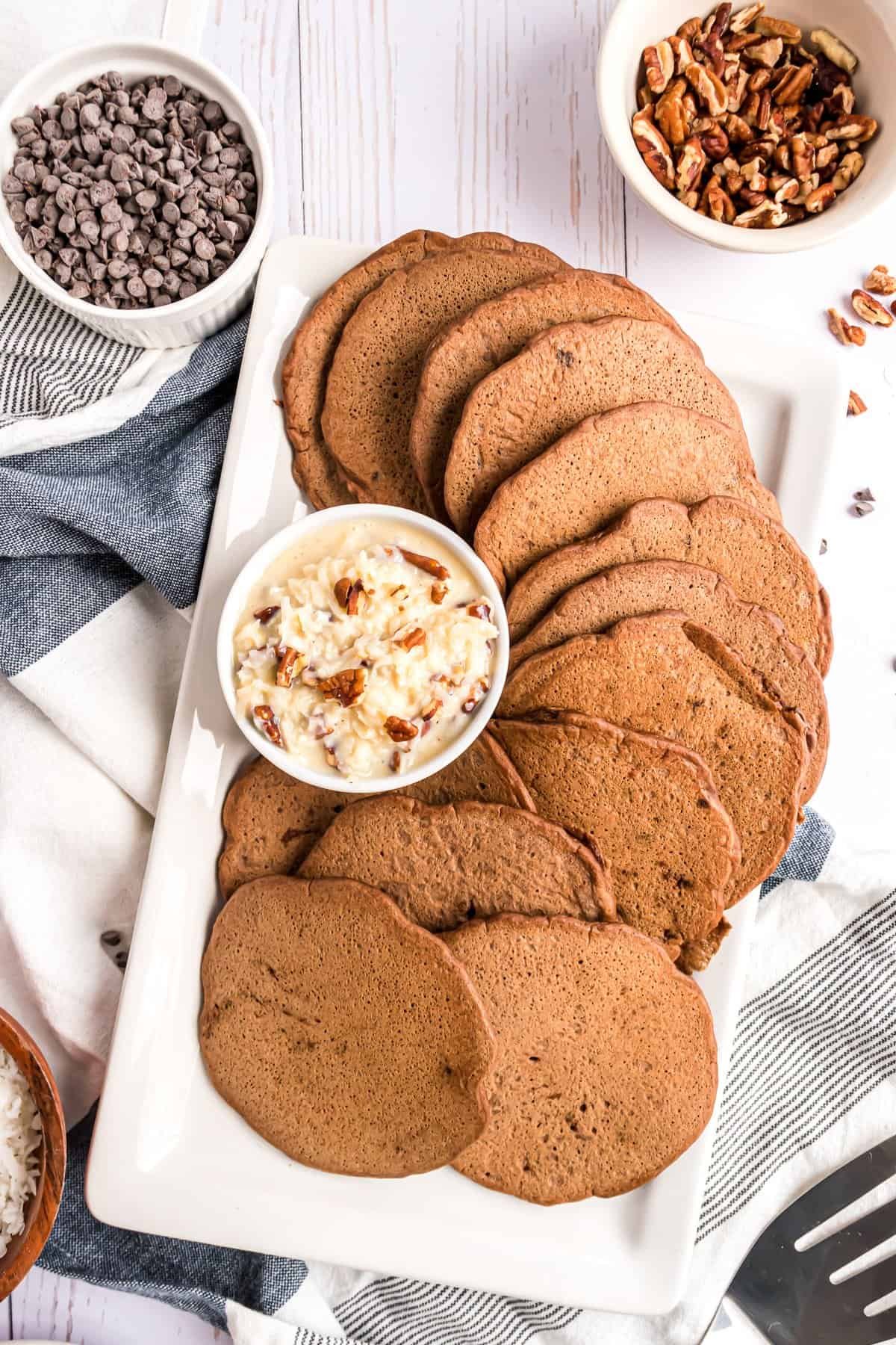 Prato de panquecas de chocolate com uma cobertura de bolo de chocolate alemão em uma tigela pequena.