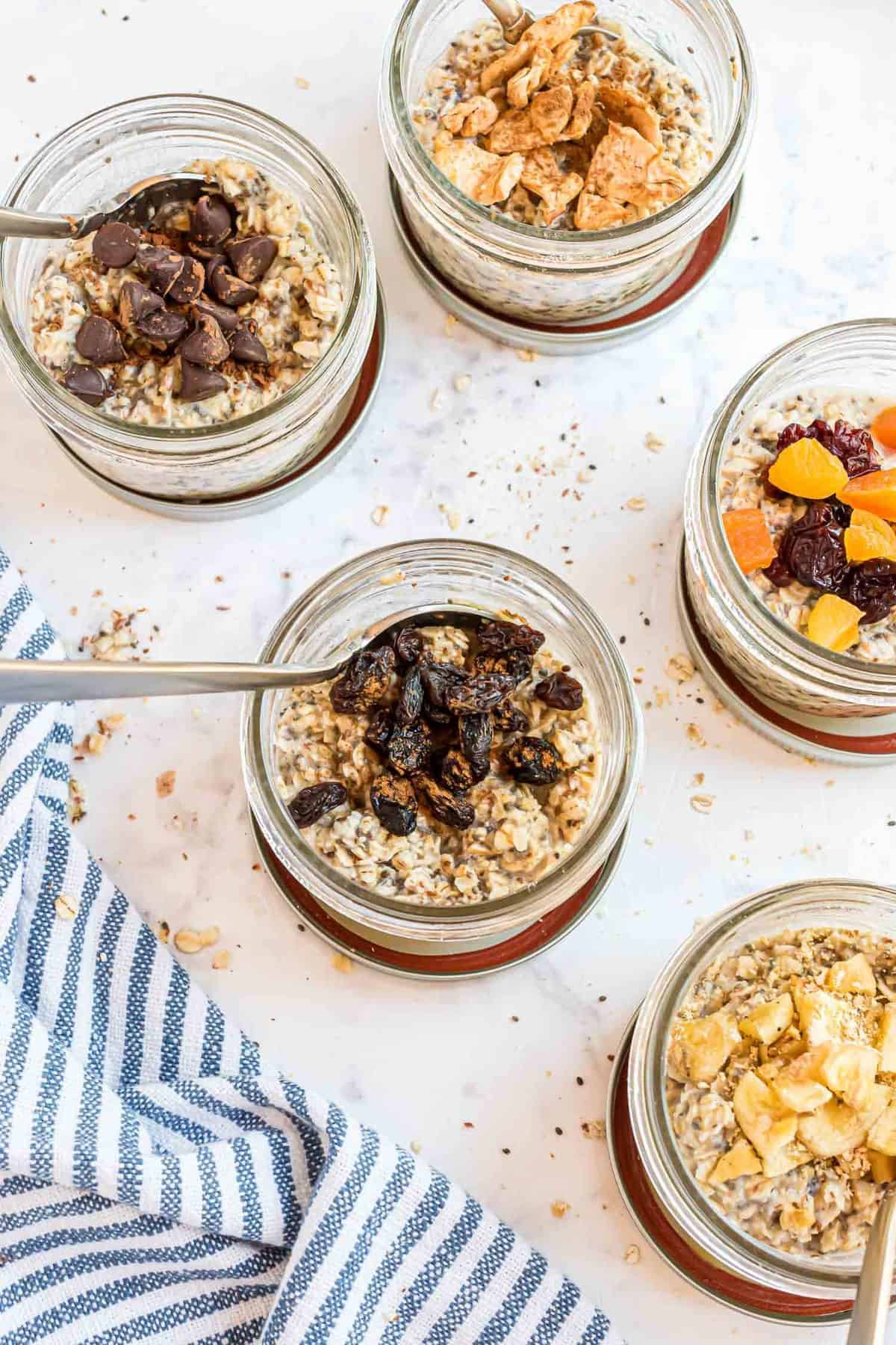Pequenos potes cheios de diferentes tipos de aveia instantânea caseira.