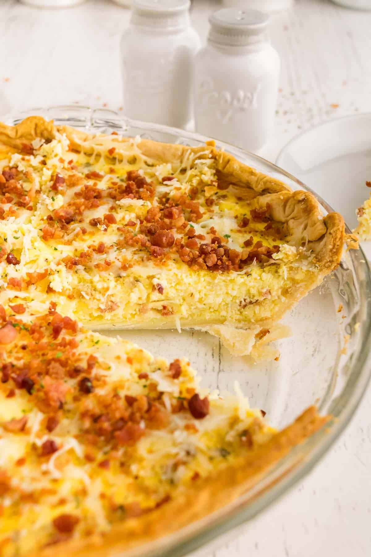 Quiche com bacon, uma fatia removida da forma.