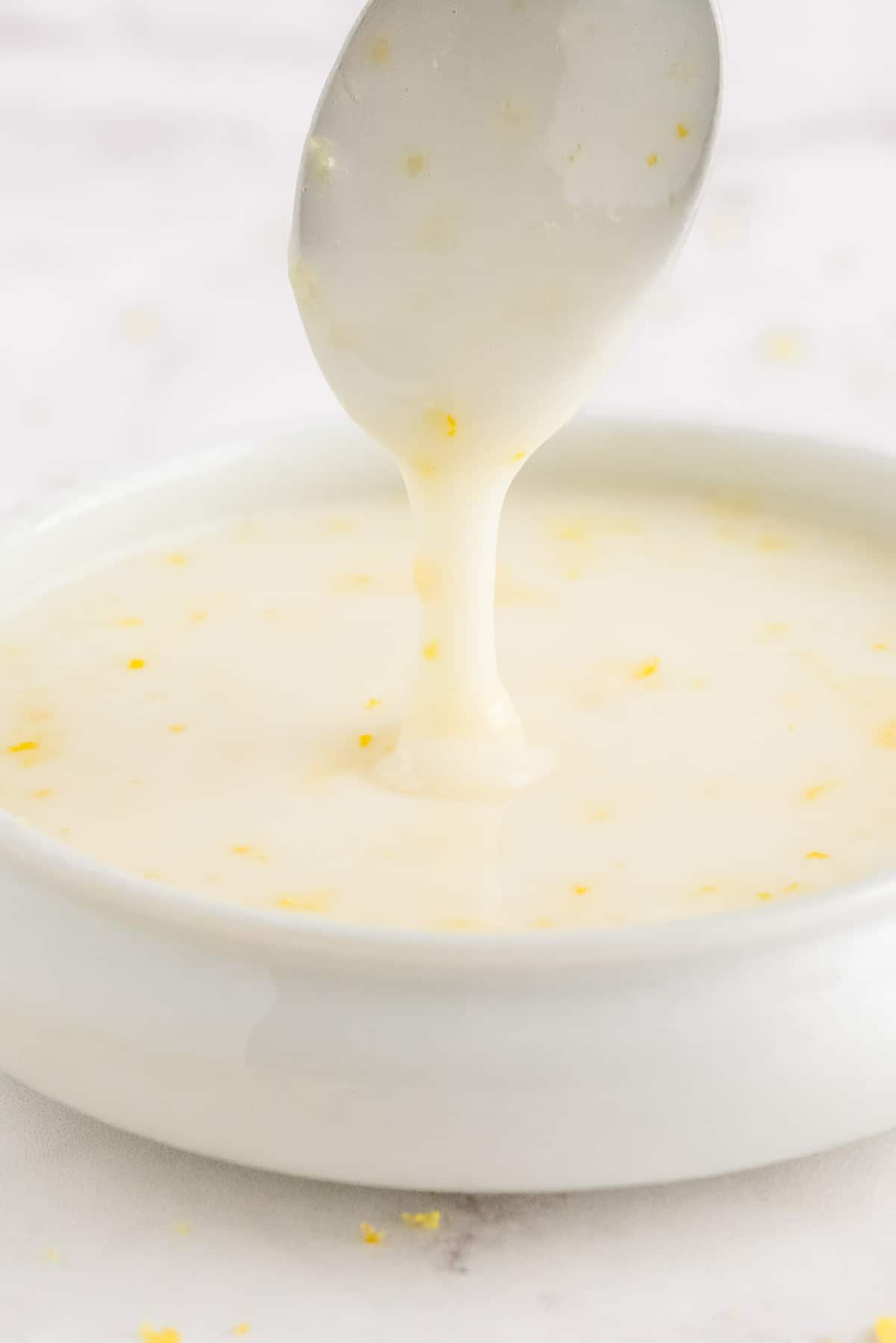 Glacê de limão escorrendo de uma colher em uma tigela