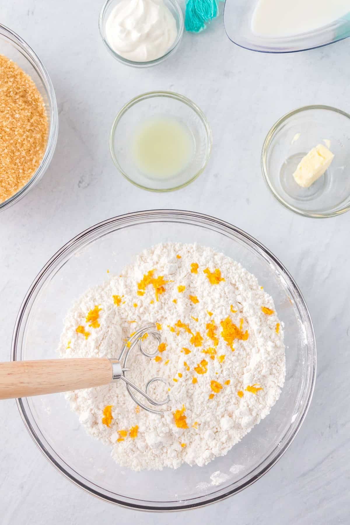 Ingredientes secos com casca de limão numa taça de mistura.