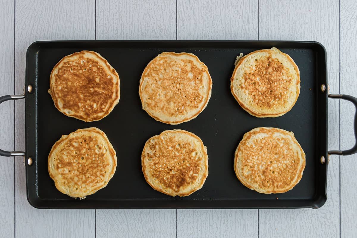 Panquecas cozinhadas numa frigideira preta.