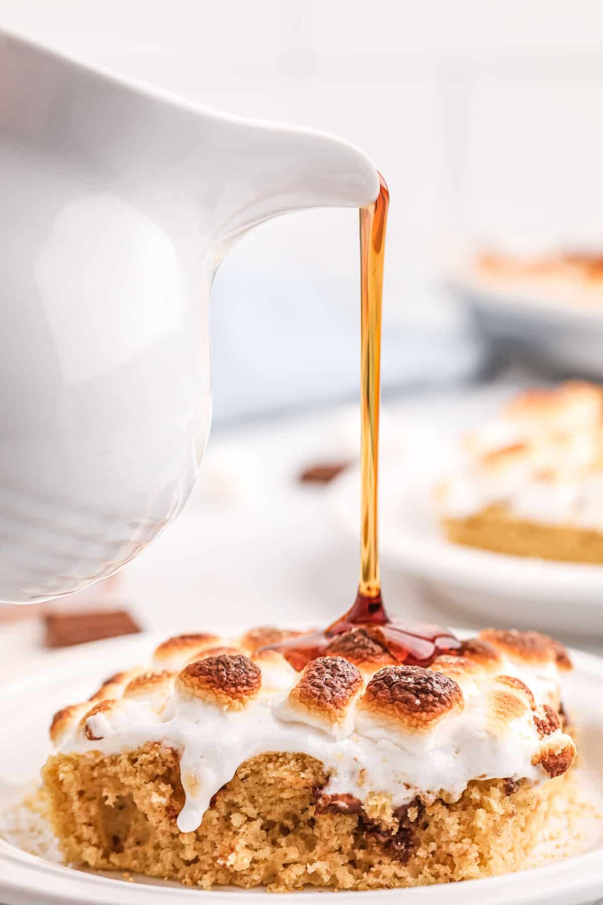 Xarope sendo derramado sobre uma panqueca com marshmallow