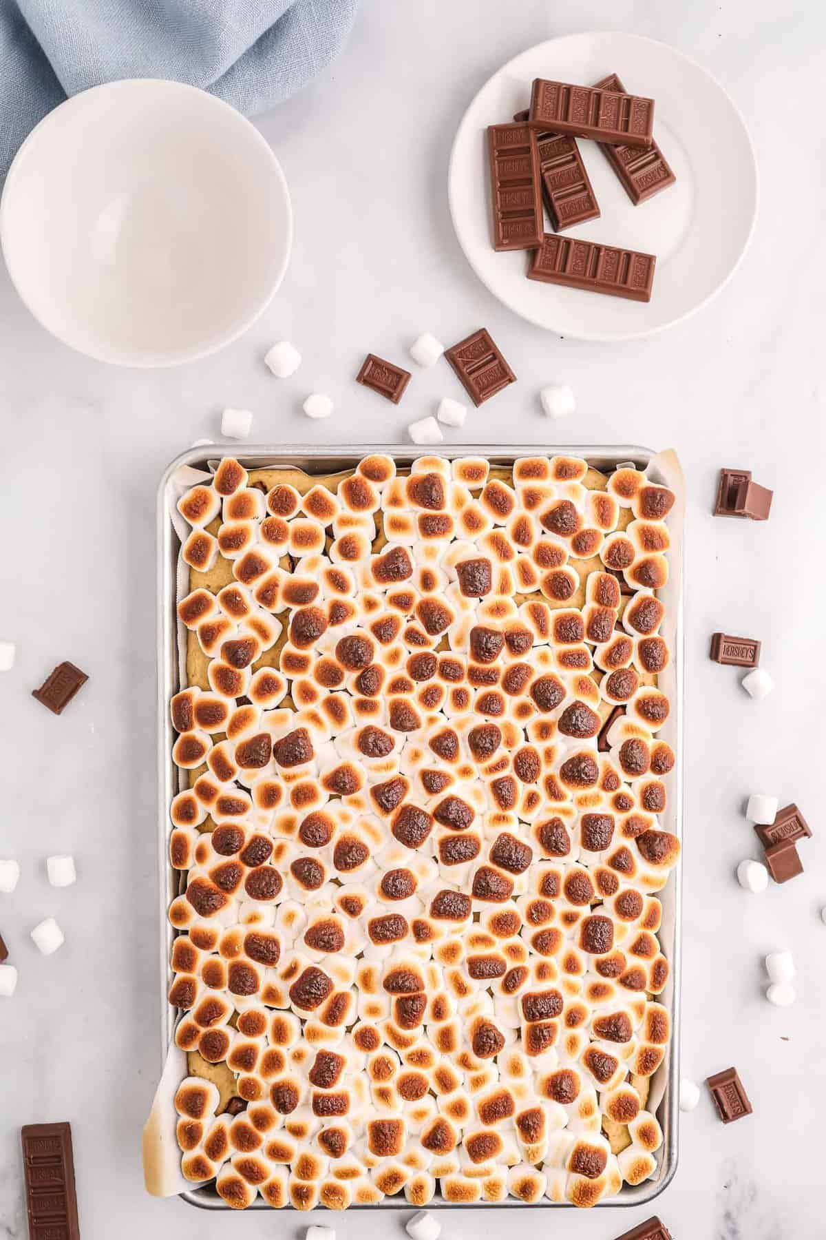 Marshmallows torrados sobre uma panqueca em uma assadeira.