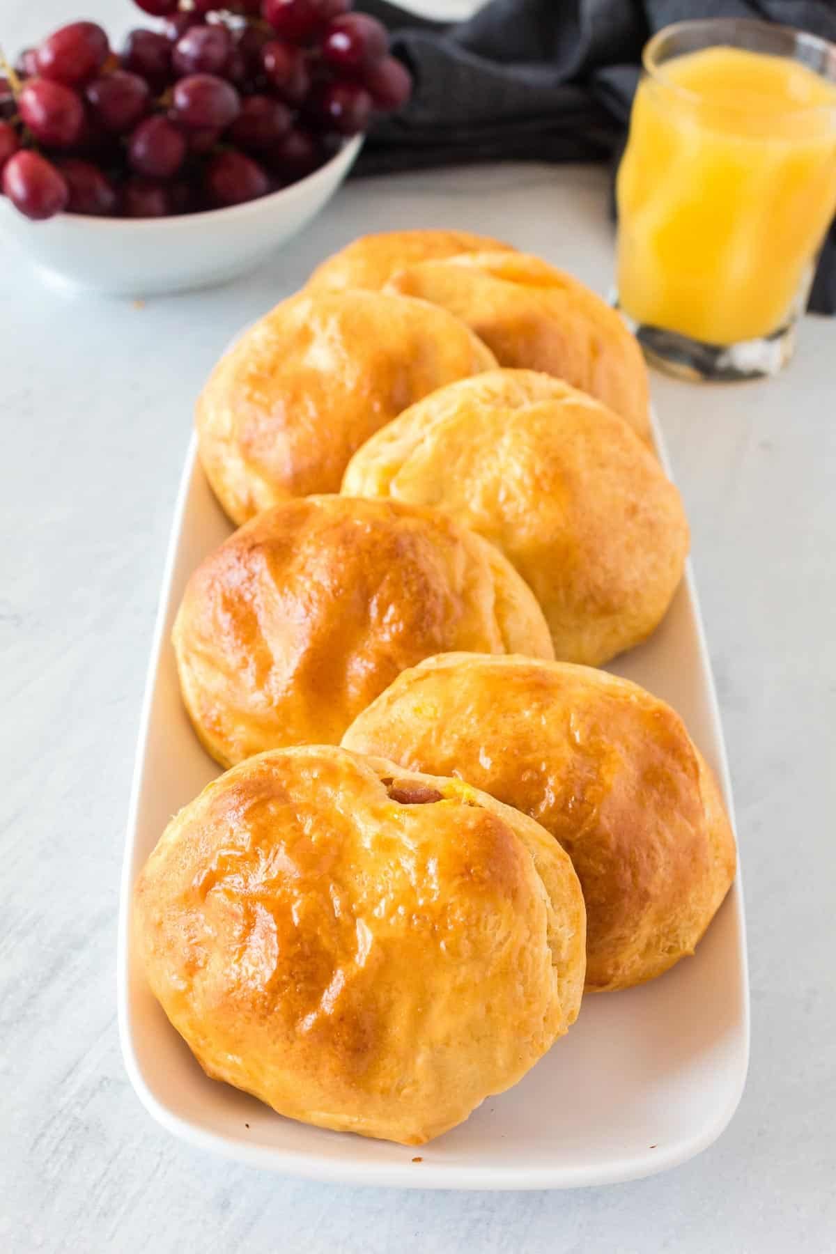 Biscoitos recheados num prato longo branco.