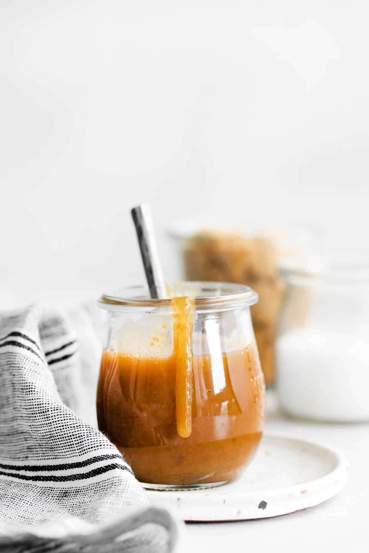 Pote de caramelo vegano com calda escorrendo pelo lado do pote.