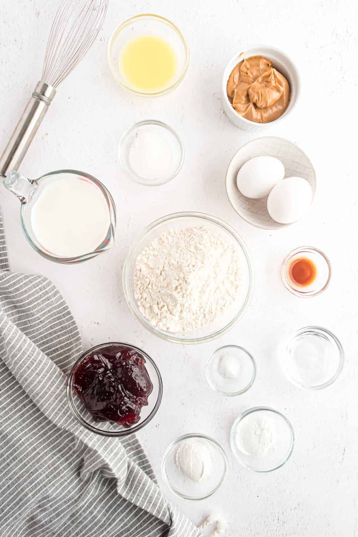 Ingredientes necessários para panquecas incluindo manteiga de amendoim e geleia.