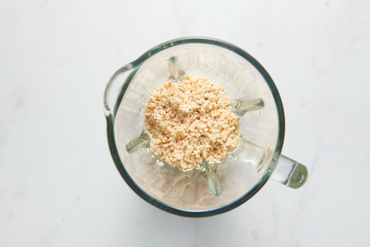 A blender pitcher with soaked urad dal and fenugreek seeds