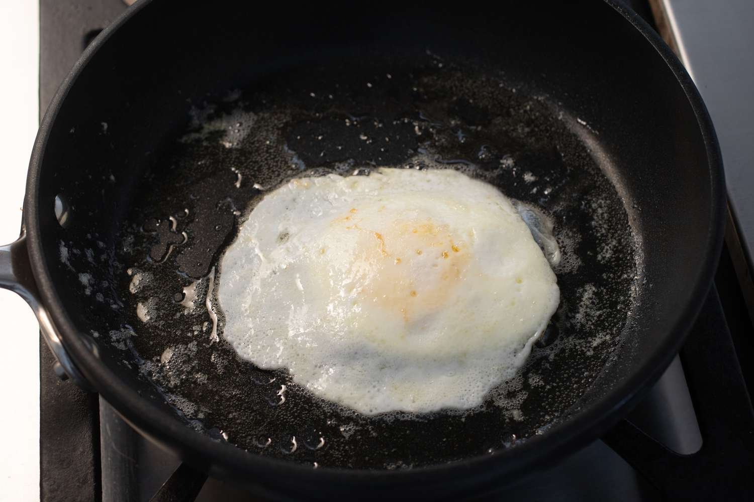 Flipped egg with all the white firm in the the skillet