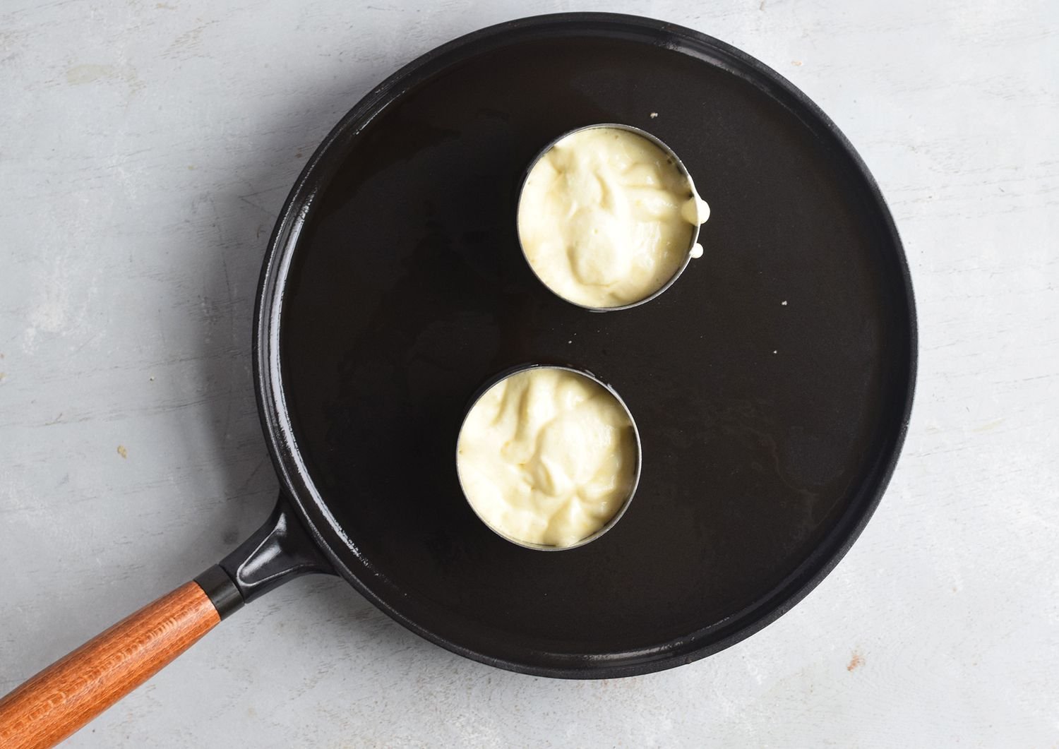 Batter in pastry rings on skillet