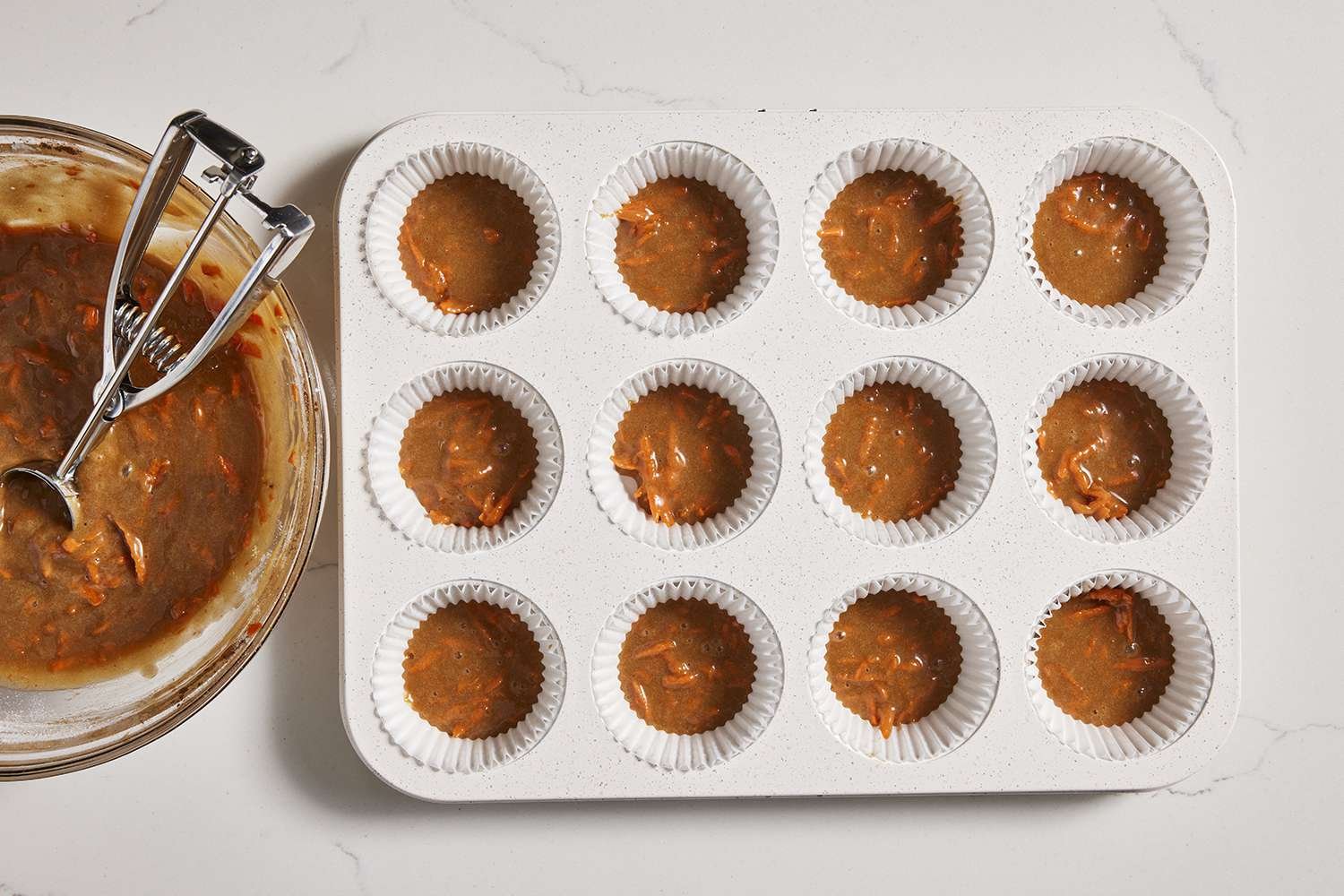 small amount of batter scooped into muffin tin
