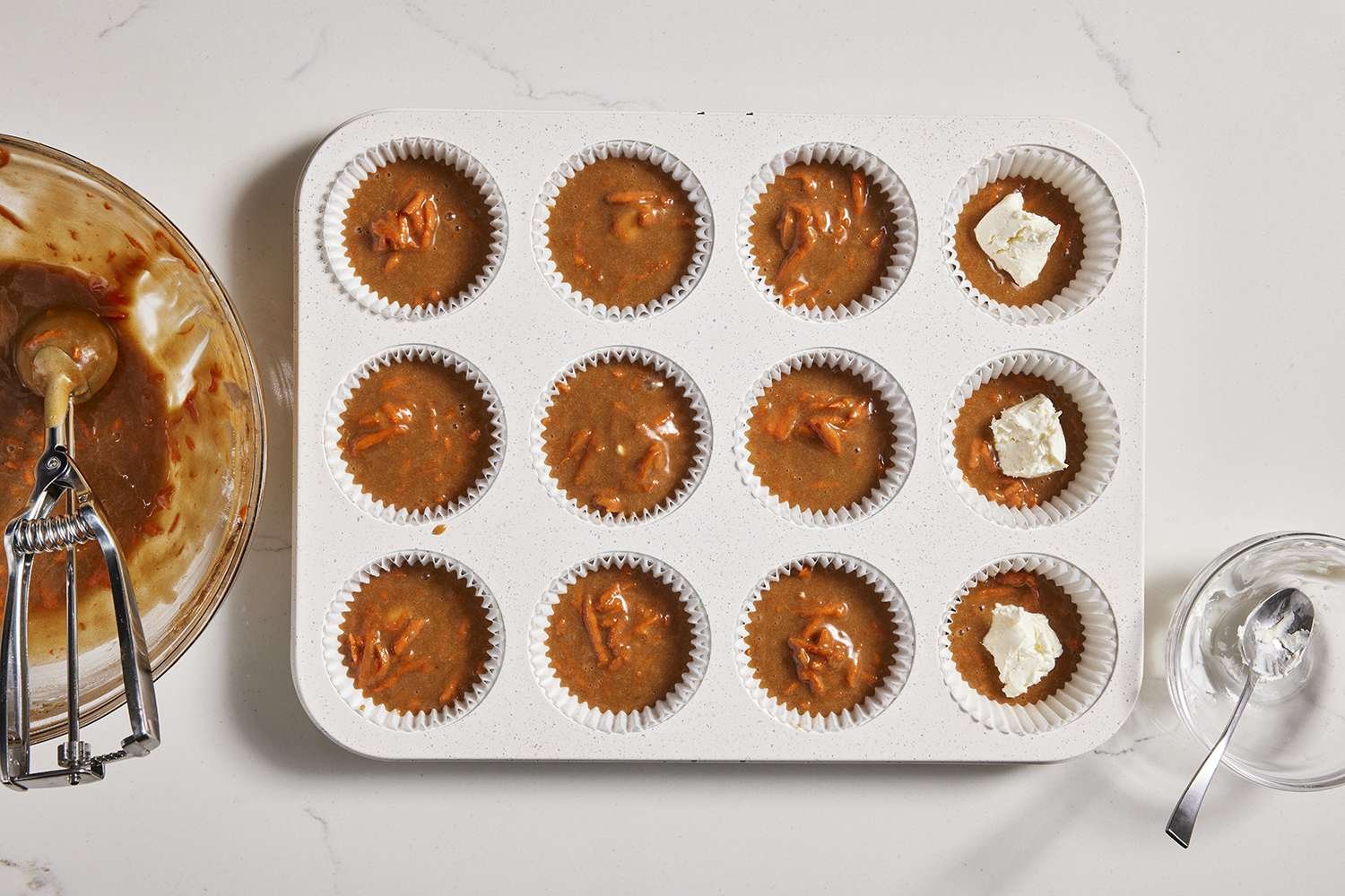 dollop of cream cheese added to each muffin cup