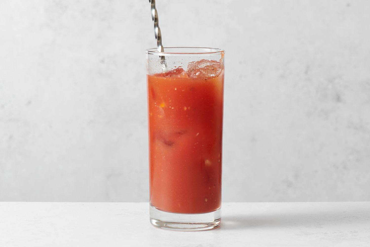 A swizzle stick stirring the drink