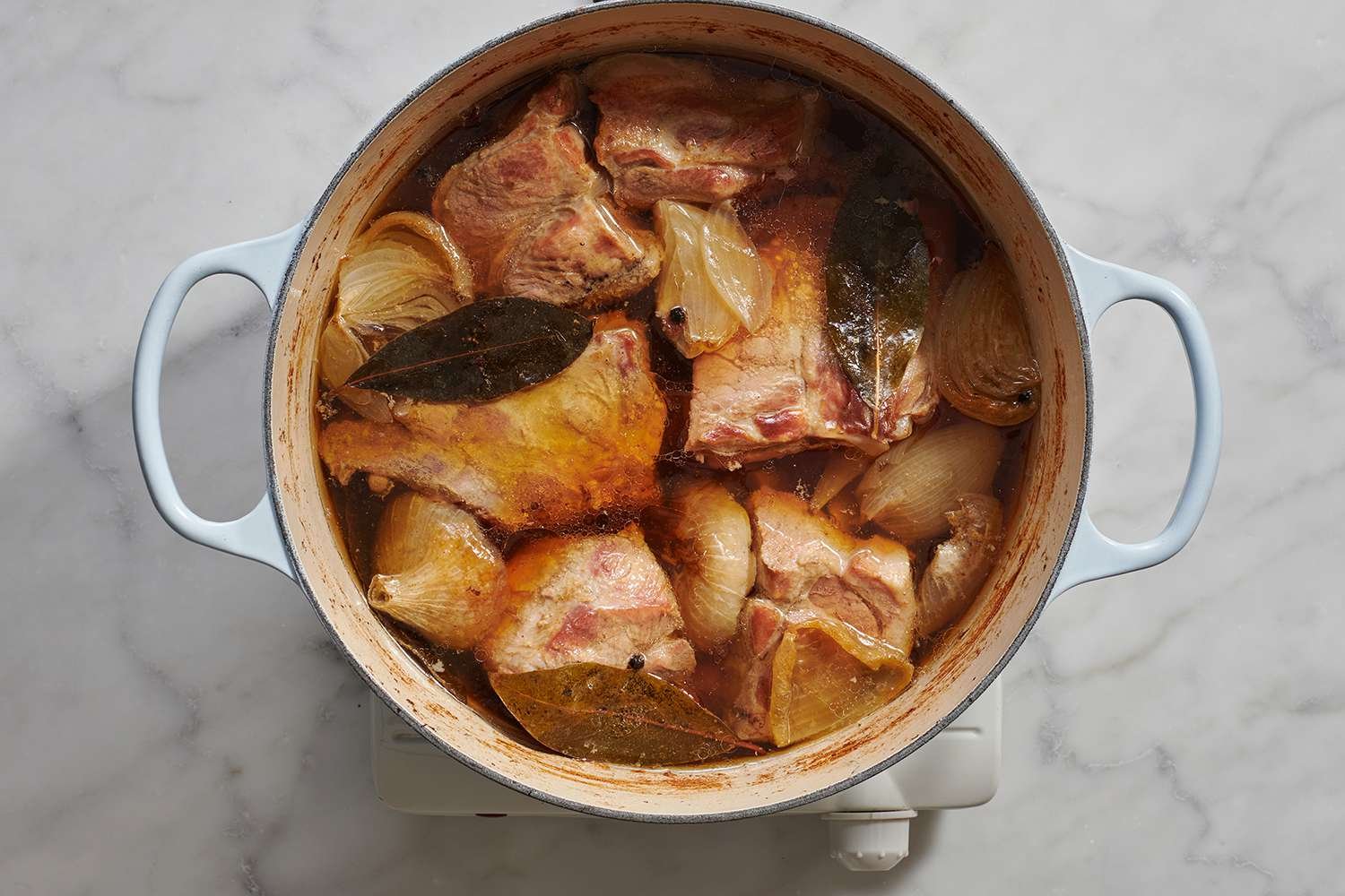 Pork meat and bones cooking in broth