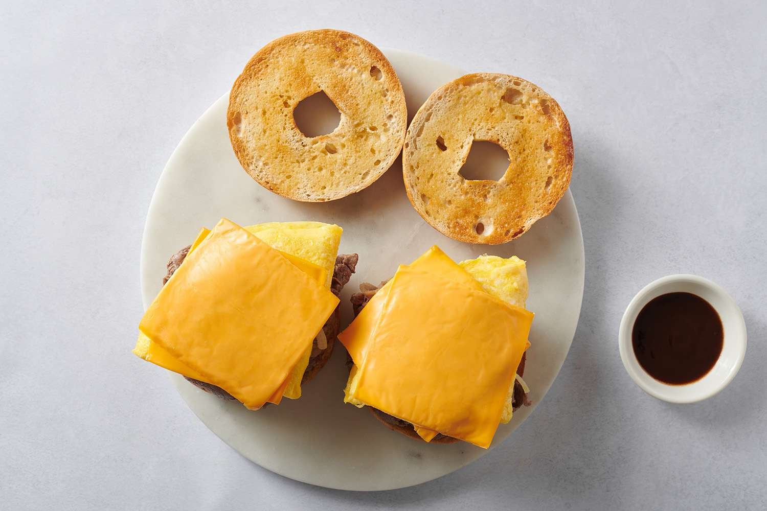 steak, egg, and cheese on sliced bagel 