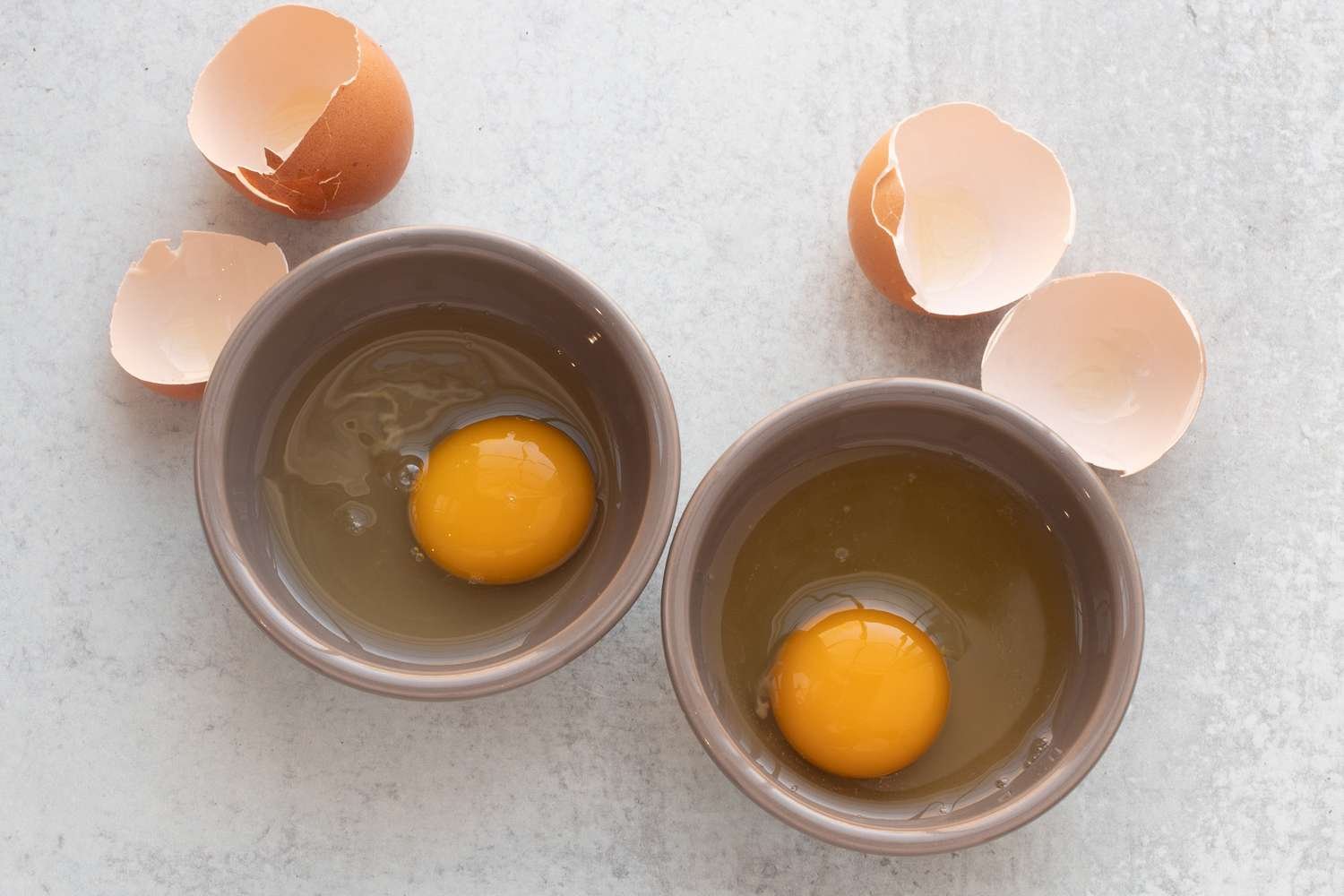 Eggs cracked into ramekins.